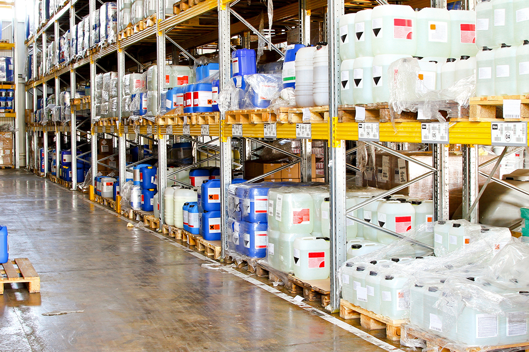 Magazijn met opgeslagen chemische producten in gelabelde containers op pallets