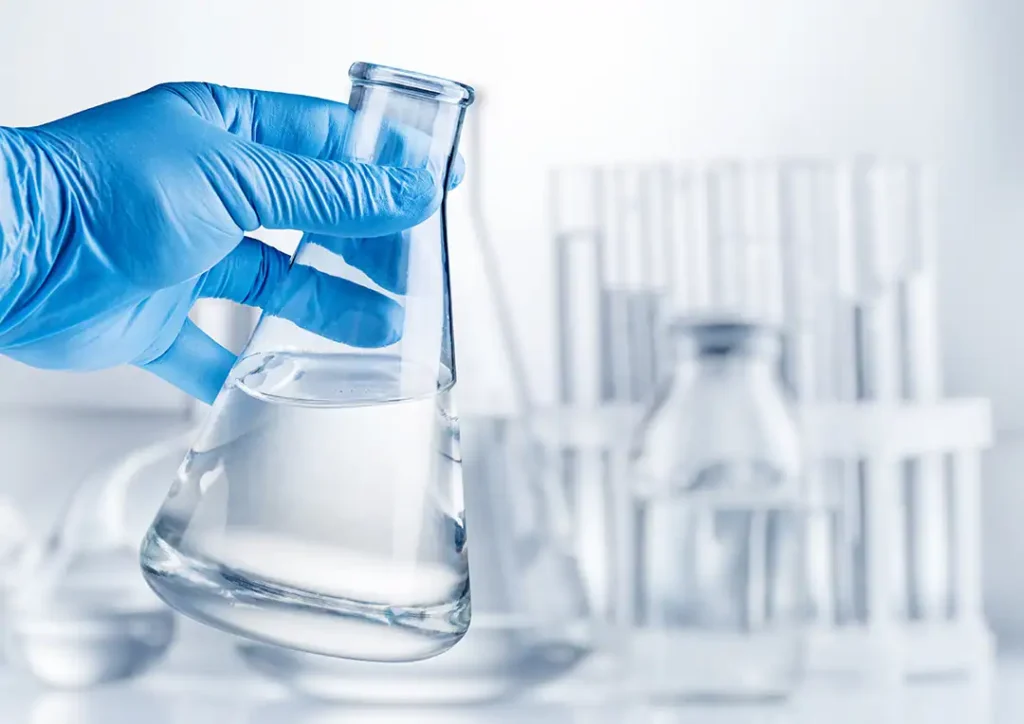laboratoriumfles gevuld met heldere gedenatureerde alcohol in een labomgeving