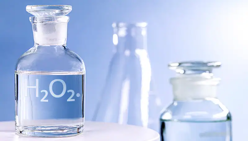 Glazen flesje met waterstofperoxide voor spoelen op een schone, witte ondergrond